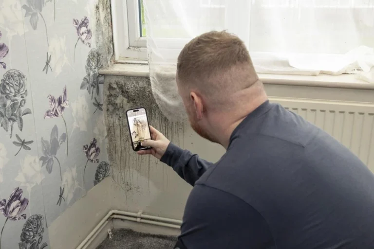 Tenant inspecting suspected mold growth on a wall in a New York City apartment