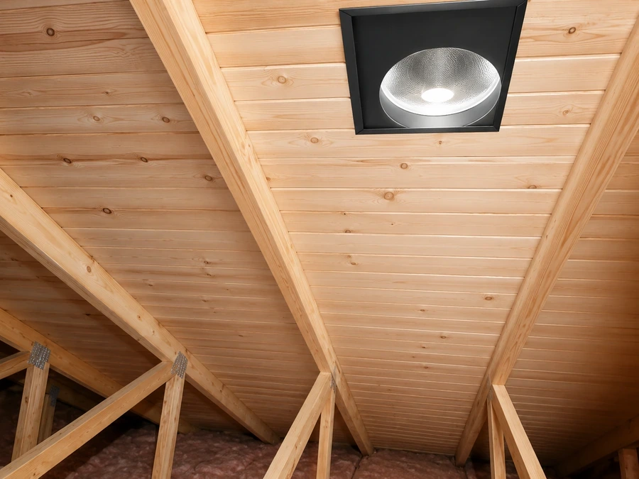 Same attic rafters with new insulation and vented exhaust fan after removal